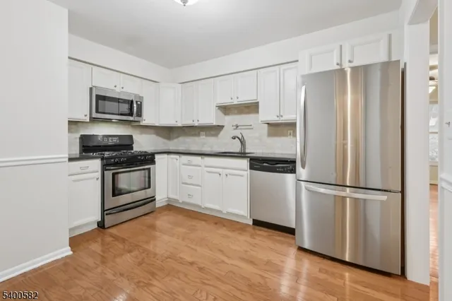 a kitchen with stainless steel appliances a refrigerator stove and microwave