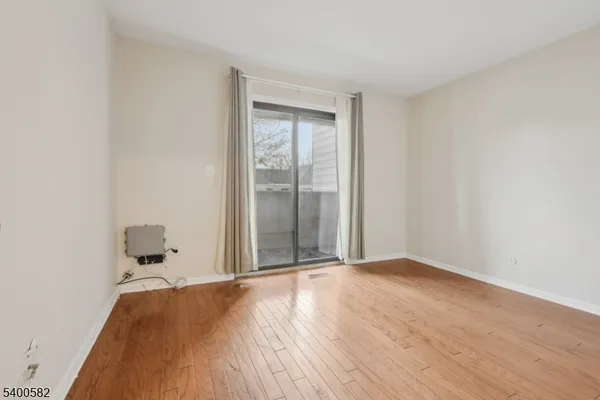a view of a room with wooden floor and white walls