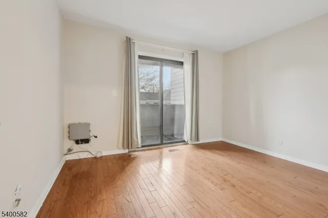 a view of a room with wooden floor and white walls