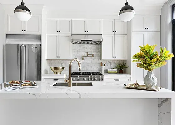 a kitchen with stainless steel appliances kitchen island granite countertop a stove a sink and a white cabinets