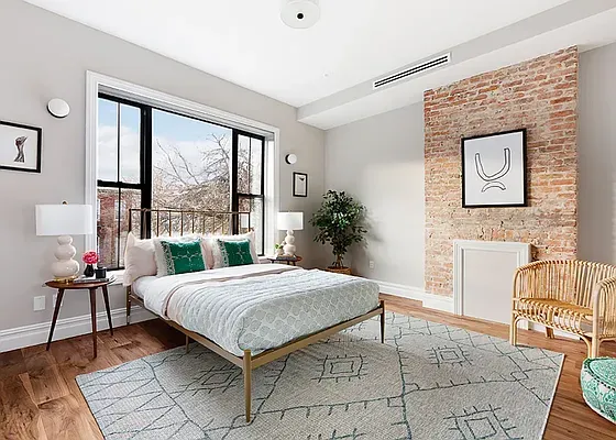 a bedroom with a bed and large windows