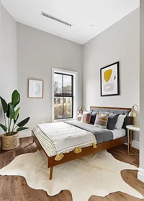 a bedroom with a bed and painting on the wall