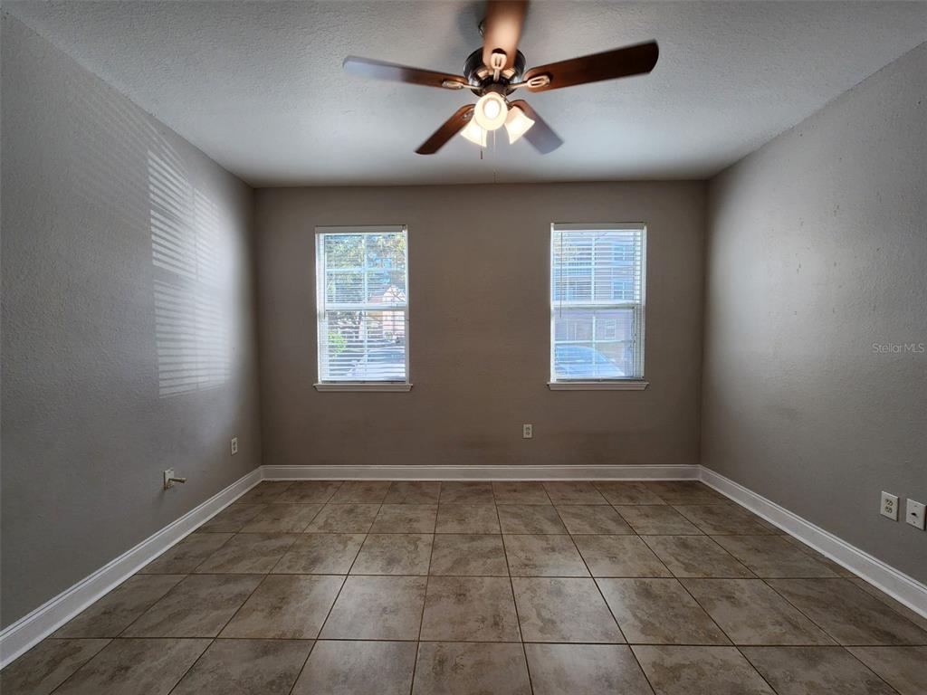 3250 Corona Village Way, Unit 101 Orlando, FL 32835 - Photo 6 of 31 a view of an empty room with a ceiling fan and window