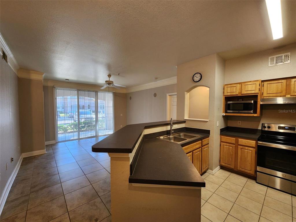 3250 Corona Village Way, Unit 101 Orlando, FL 32835 - Photo 9 of 31 a kitchen with granite countertop a stove and a sink