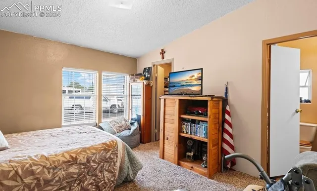 a bedroom with a bed and a large window