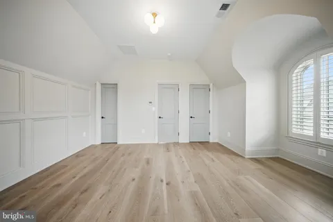 a view of a hallway with wooden floor and stairs