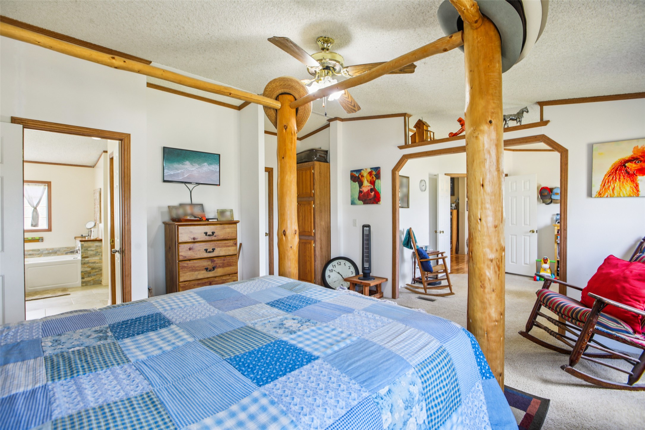372 Hofferek Road Rosanky, TX 78953 - Photo 15 of 40 Carpeted bedroom featuring a textured ceiling, crown molding, a closet, ensuite bath, and ceiling fan