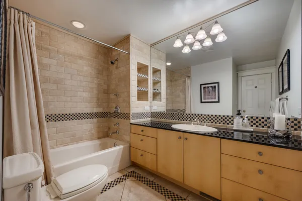 a bathroom with a sink a toilet a mirror and shower