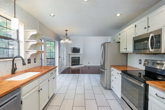 a large kitchen with stainless steel appliances granite countertop a sink and cabinets