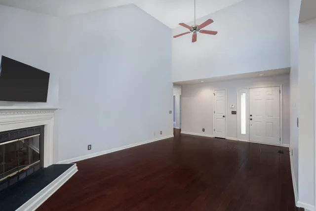 an empty room with a fireplace and wooden floor