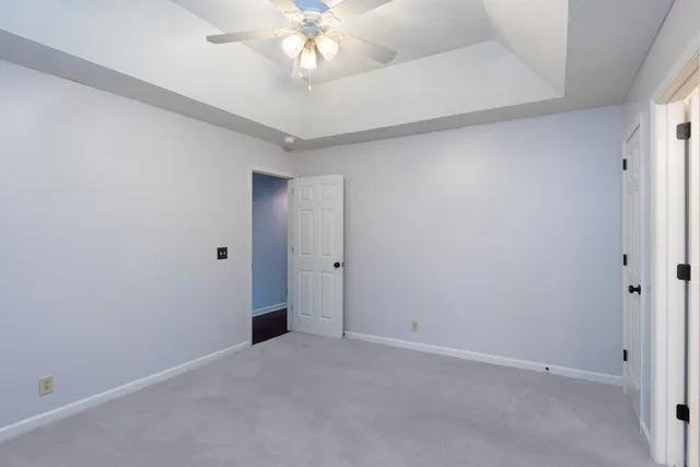 a view of an empty room with a chandelier fan