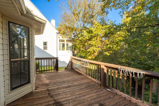 a view of a balcony with wooden floor and fence
