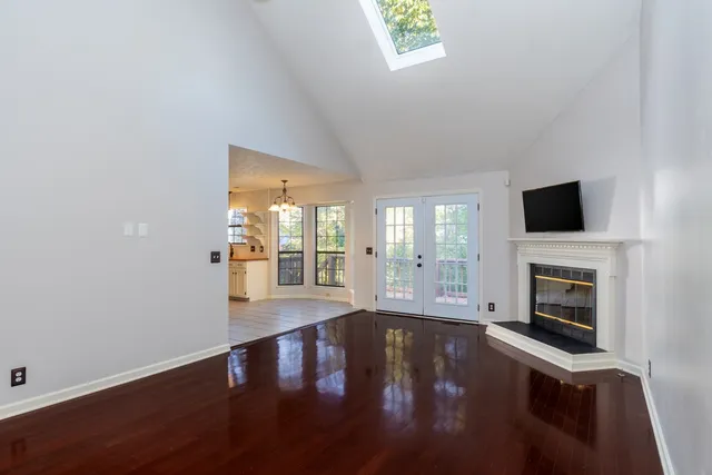 a view of empty room with fireplace and wooden floor