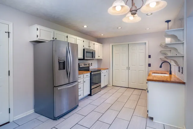 a kitchen with stainless steel appliances a refrigerator sink and cabinets