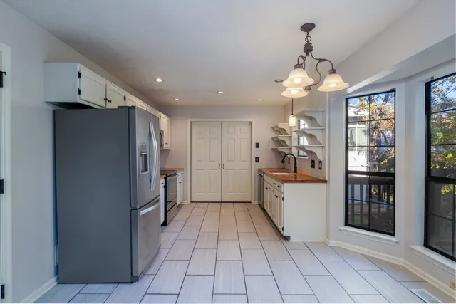 a kitchen with stainless steel appliances granite countertop a refrigerator and a sink