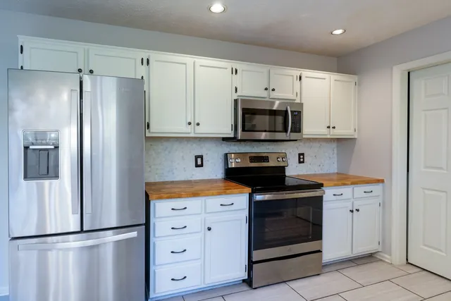 a kitchen with white cabinets and stainless steel appliances