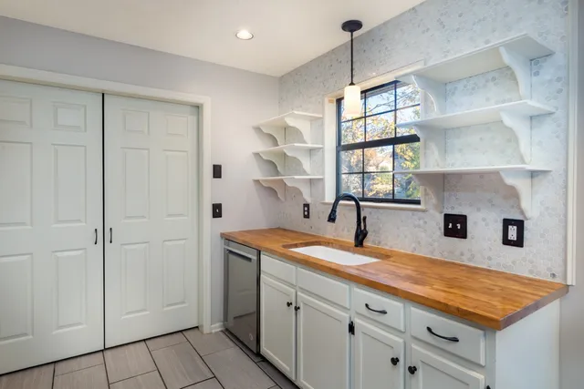 a kitchen with a sink cabinets and a window