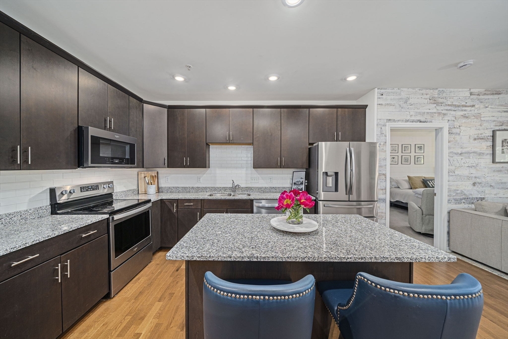 70 Trotter Road, Unit 310 Weymouth, MA 02190 - Photo 2 of 14 a kitchen with stainless steel appliances granite countertop a kitchen island sink stove and refrigerator