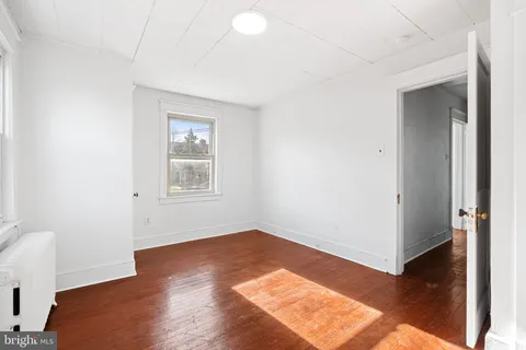 a view of a room with wooden floor and white walls
