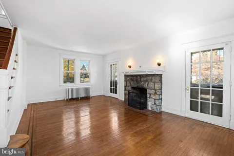 an empty room with windows and fireplace