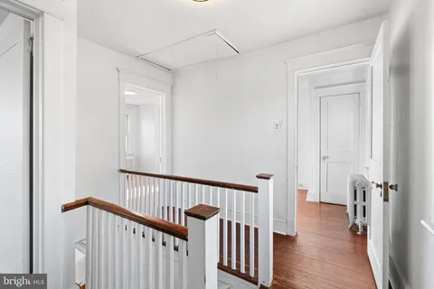 a view of a hallway with wooden floor and staircase