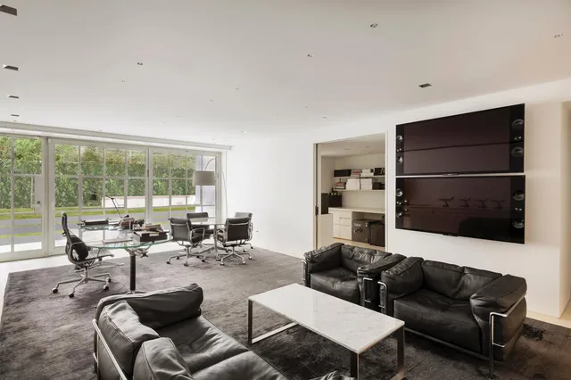 a living room with furniture ceiling fan and a large window