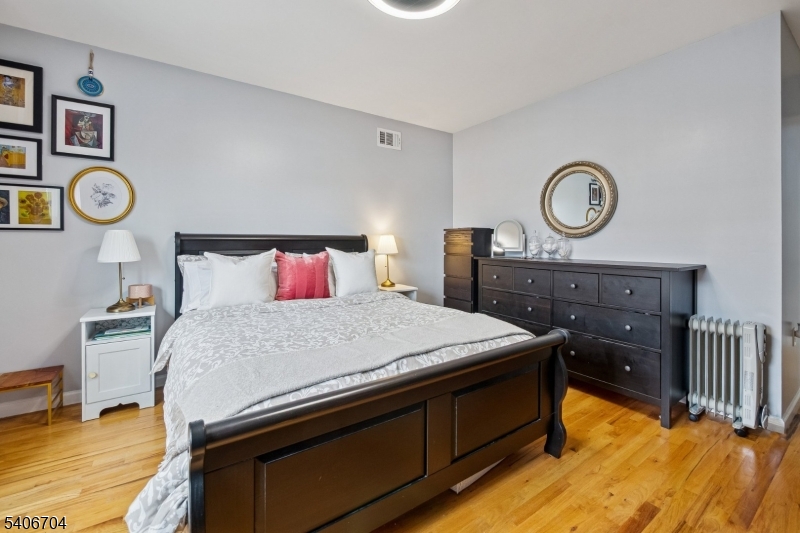 111 Todd Street Linden, NJ 07036 - Photo 14 of 34 a bedroom with a bed and a closet with wooden floor