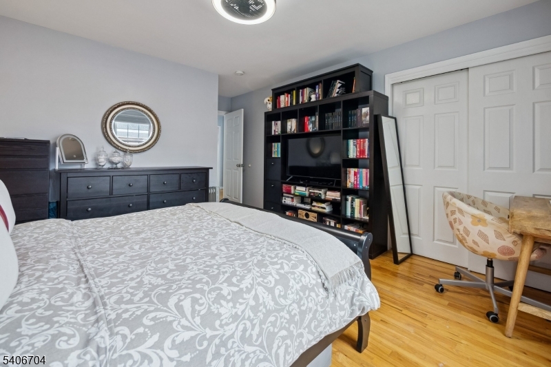 111 Todd Street Linden, NJ 07036 - Photo 22 of 34 a bedroom with a bed a table and a bookshelf