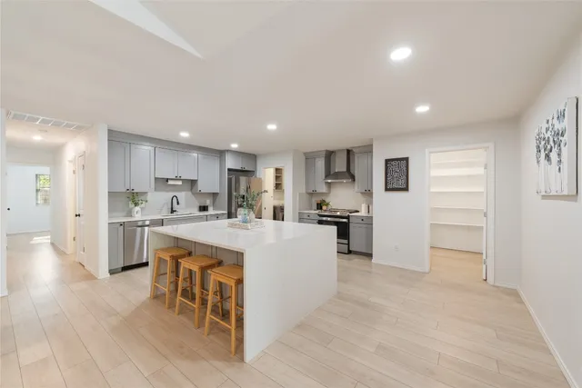 a kitchen with white cabinets and stainless steel appliances