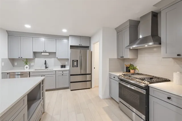 a kitchen with stainless steel appliances a sink stove and refrigerator