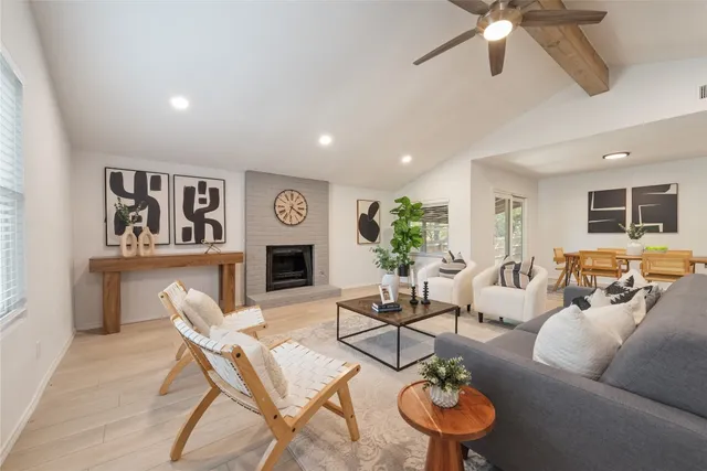 a living room with furniture a fireplace and a chandelier