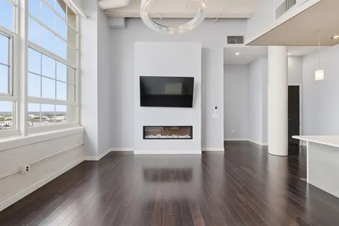 a view of a livingroom with wooden floor and a fireplace