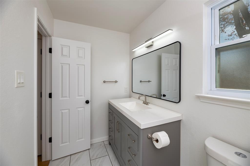485 Ashley Lane Roanoke, TX 76262 - Photo 14 of 28 a bathroom with a sink and mirror with toilet