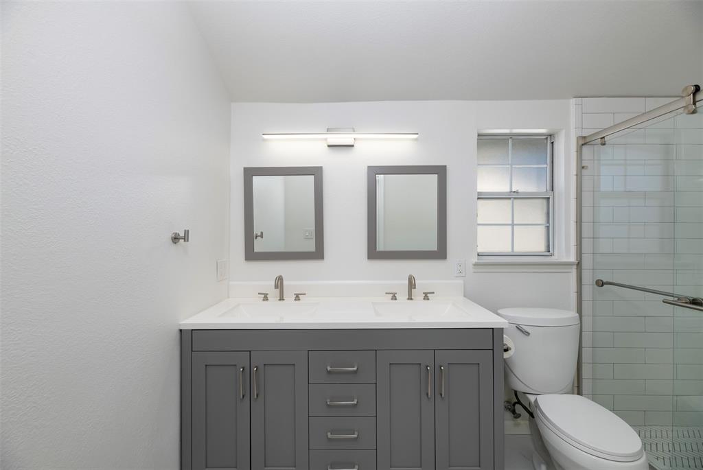 485 Ashley Lane Roanoke, TX 76262 - Photo 19 of 28 a bathroom with a double vanity sink toilet and a mirror