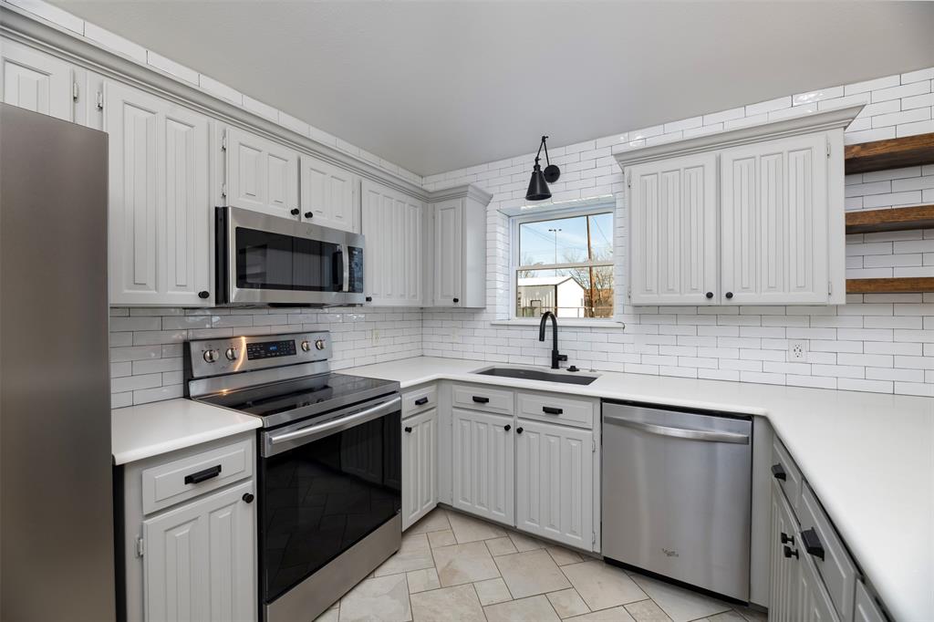 485 Ashley Lane Roanoke, TX 76262 - Photo 7 of 28 a kitchen with white cabinets appliances and a sink