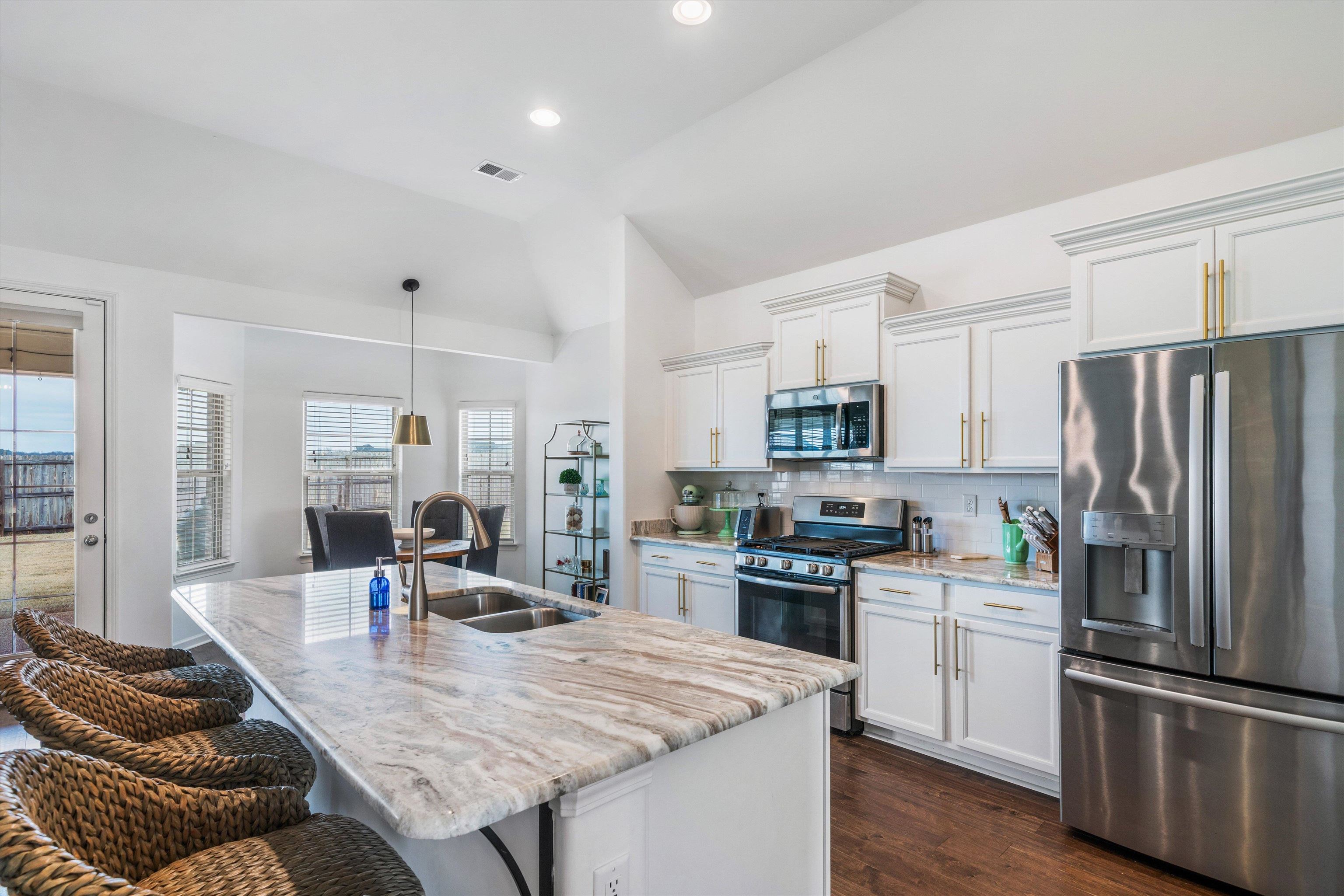 75 Cypress Point Road Oakland, TN 38060 - Photo 5 of 38 a kitchen with stainless steel appliances granite countertop a refrigerator a stove a sink a dining table and chairs
