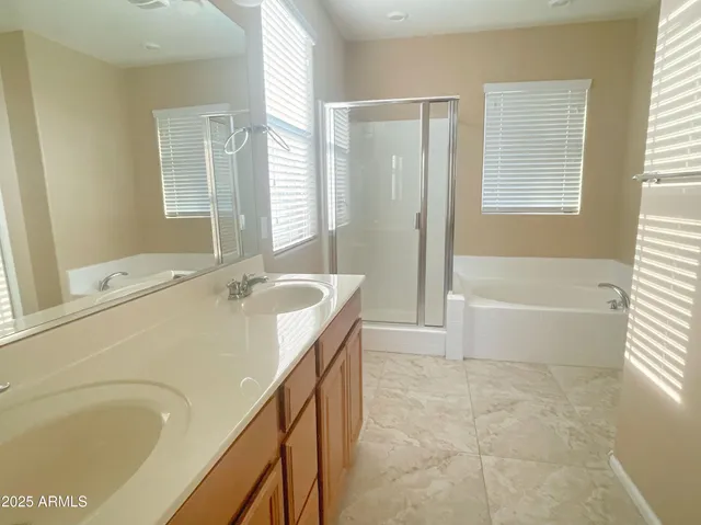 a bathroom with a granite countertop tub a sink and a large mirror