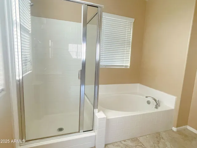 a white bath tub sitting next to a shower