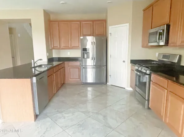 a kitchen with stainless steel appliances granite countertop a refrigerator stove and sink