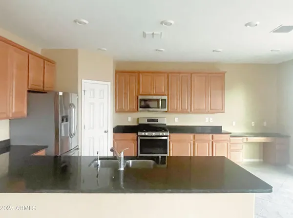 a kitchen with a stove a refrigerator and a sink with cabinets