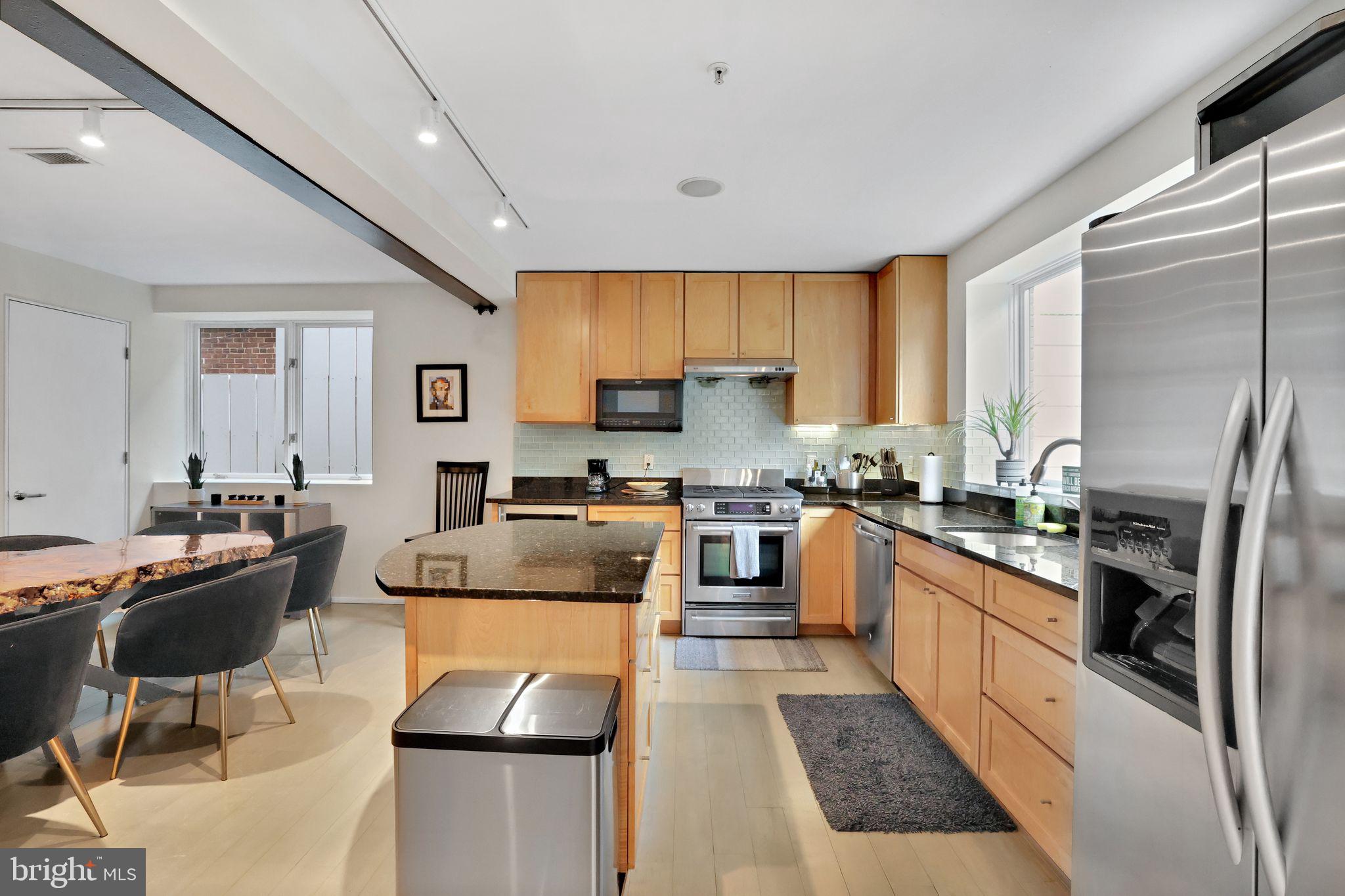 2311 15th Street Northwest, Unit 2 Washington, DC 20009 - Photo 12 of 37 a kitchen with stainless steel appliances granite countertop a refrigerator a stove top oven a sink dishwasher and white cabinets next to a window