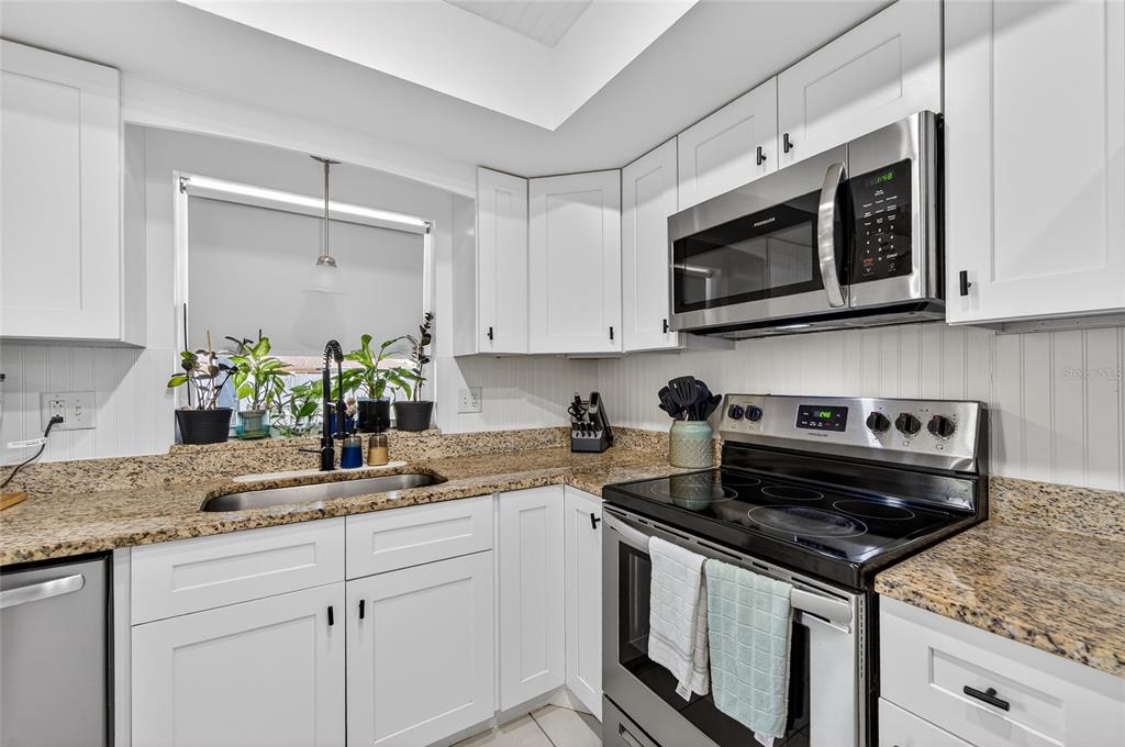 532 Center Road Venice, FL 34285 - Photo 42 of 68 a kitchen with stainless steel appliances granite countertop a sink stove and microwave