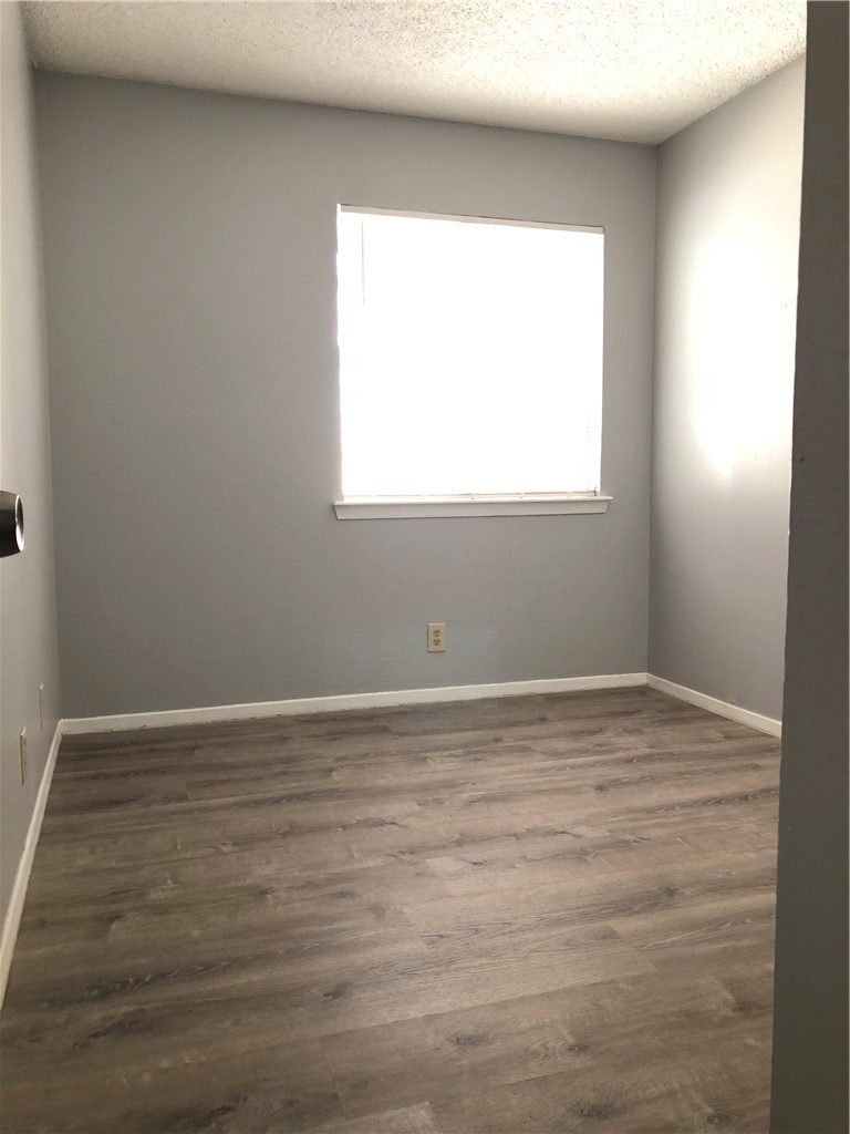 6502 South 1st Street, Unit 102 Austin, TX 78745 - Photo 12 of 26 a view of an empty room with wooden floor and a window