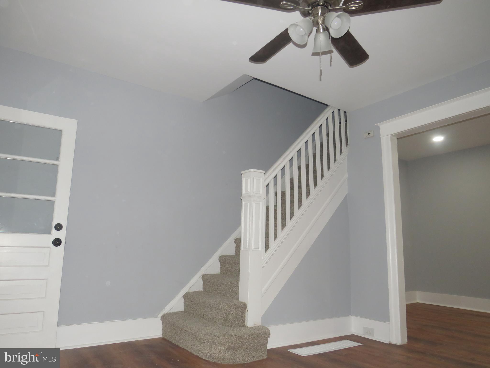a view of staircase with white walls and railing