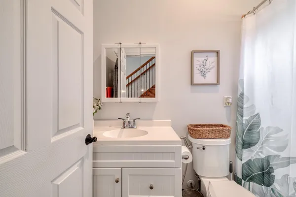 a bathroom with a toilet sink and mirror