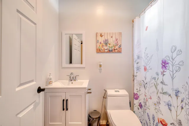 a bathroom with a toilet sink and mirror