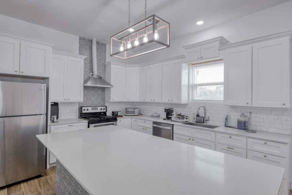 1601 County Road 466 Elgin, TX 78621 - Photo 29 of 39 a kitchen with white cabinets and stainless steel appliances