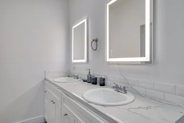 a bathroom with a double vanity sink mirror and