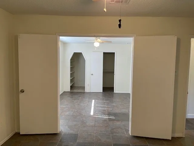 a view of a hallway with wooden floor and a cabinet