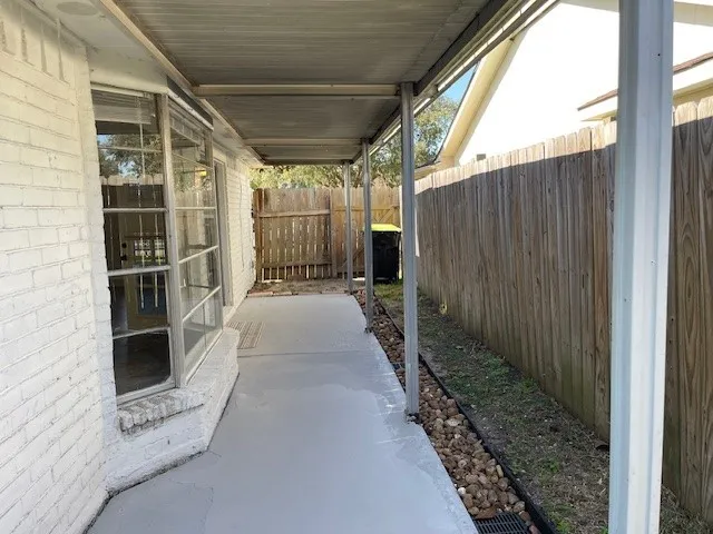 a view of a pathway of a house with wooden fence